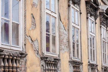 Eski bir binanın, Sırbistan 'ın Voyvodina kentindeki bir çiftliğin yerleşim yerinin, hasarlı ve çürümeye yüz tutmuş ön cephesinin üzerindeki seçici bulanık pencereler yenilenmeye hazır