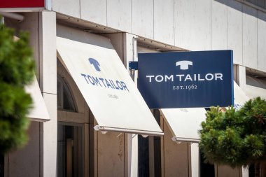 LJUBLJANA, SLOVENIA - 13 Haziran 2021: Tom Tailor logosu Ljubljana için dükkanlarının önünde. Tom Tailor, tüm dünyaya yayılmış bir moda perakendecisi Alman zinciri.