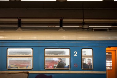 BELGRAD, SERBIA - 11 Nisan 2021: Coronavirus covid 19 sağlık krizi sırasında toplu taşımada solunum maskesi takan bir banliyö treninin (Beovoz) penceresindeki insanlar için seçici bulanıklık