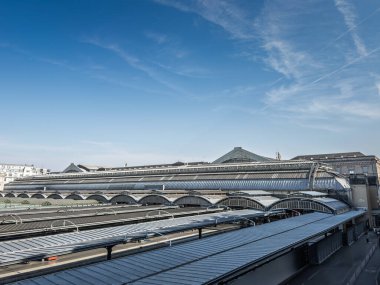 Paris Gare de l 'Est' in panoramik çatısı, cam ve çelik tren kulübeleri ve temiz bir gökyüzünün altındaki platform örtüleri. Gare de l 'est tarihi bir tren istasyonu ve Fransız demiryollarının altyapısı..