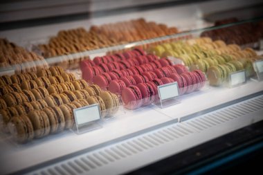 Paris 'teki bir pastanede satılık badem kremalı kurabiyeleri, Fransız mutfağının sembolünü gösteren ahududu ve şam fıstığı parçalarına odaklanmış renkli makaronlar..