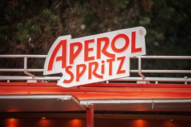 BELGRAD, SERBIA - 14 Eylül 2025: Sırbistan 'ın başkenti Belgrad' daki parlak turuncu bar tezgahının üzerine monte edilmiş Aperol Spritz logosu, Prosecco ve soda ile karıştırılmış İtalyan aperatifi kokteylini tanıtıyor.