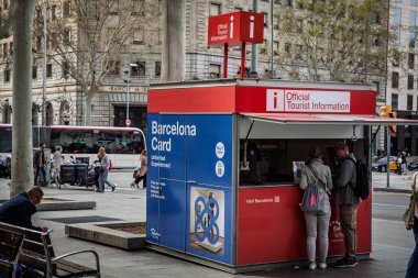 BARCELONA, SPAIN - 5 Nisan 2025: Barcelona Kartını işlek bir şehir caddesinde tanıtan resmi turizm bilgi kiosku, tezgahta bekleyen ziyaretçilerle, Barselona 'da turizm büyüyor.
