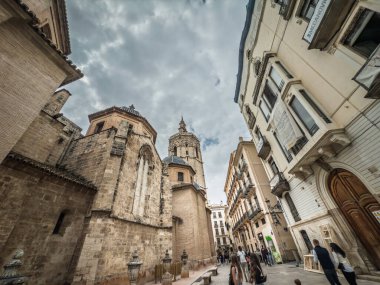 Valencia, İspanya - 10 Nisan 2025 Valencia Ciutat Vella eski kasabası Valensiya Katedrali 'nin dış yüzünü ve şehir merkezinin dar sokaklarından Miguelete çan kulesini gösteriyor..