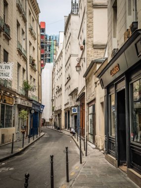 PARIS, FRANCE - 22 Haziran 2025: Paris 'in Le Marais bölgesinde, Fransız başkentinin tarihi merkezinde, yüksek tarihi binalarla çevrili dar, boş bir kaldırım taşı caddesi manzarası.