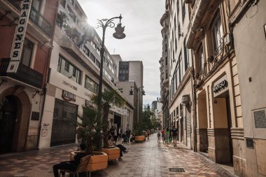 VALENCIA, İspanya - 6 Nisan 2025: İspanya ekonomisinin ve tüketiminin sembolü olan Valencia şehir merkezindeki işlek bir alışveriş caddesi olan Calle de Don Juan de Austria boyunca yürüyen yayalar.