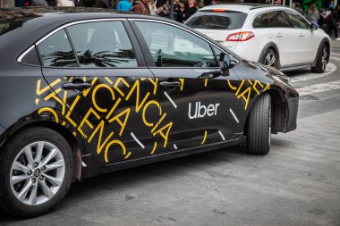 VALENCIA, İspanya - 12 Nisan 2025 Uber logosu ve Valencia metni ile damgalanmış siyah bir Toyota araba. Uber bir teknoloji şirketidir..
