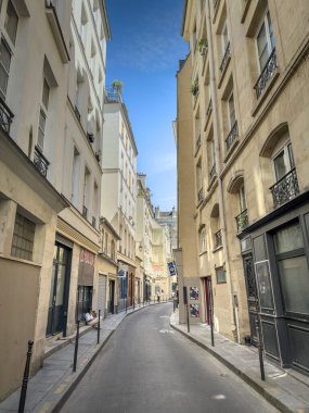 PARIS, FRANCE - 24 Haziran 2025: Paris 'in Le Marais bölgesinde, Fransız başkentinin tarihi merkezinde, yüksek tarihi binalarla çevrili dar, boş bir kaldırım taşı caddesi manzarası.