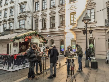 BELGRAD, SERBIA - 1 Ocak 2026: Tatil sezonu boyunca Belgrad 'daki Knez Mihailova Caddesi' ndeki bir Noel pazarında uzun masalarda durup sıcak şarap içen insanlar.
