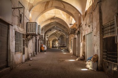 İran 'daki Kashan Çarşısı' nın boş bir sokağı. Kapalı dükkanlar ve yumuşak ışıklarla dolu bir koridor. Geleneksel Ortadoğu pazar mimarisini vurguluyor..