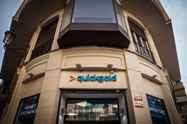 VALENCIA, İSPA - 8 Nisan 2025: Valencia, İspanya 'da bir köşedeki bir binanın Quickgold mağaza vitrini ve logosu, döviz ve altın alım-satımı konusunda uzmanlaşmış bir zincir..