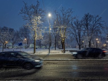 Sırbistan 'ın Belgrad kentindeki ıslak bir bulvarda, trafik ışıkları ve tramvay kablolarıyla aydınlatılan hareketli arabalar yoğun kar yağışı altında geçiyor. Kış sürüşü, çamur ve düşük görüş mesafesi günlük banliyö sakinleri.
