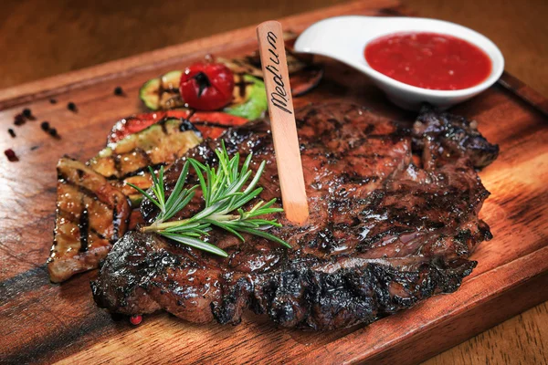 Bistecca di carne sulla tavola di legno — Foto Stock