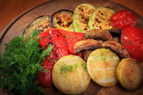 Légumes cuits au four sur une planche de bois — Photo