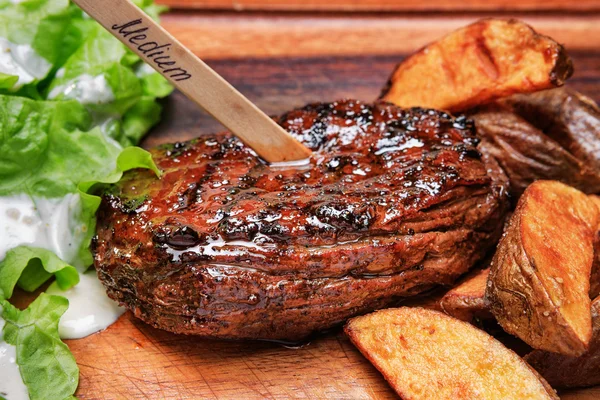 Beef steak with french fries and lettuce — Stock Photo, Image