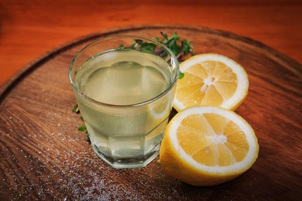 Een glas limonade op een houten bord — Stockfoto