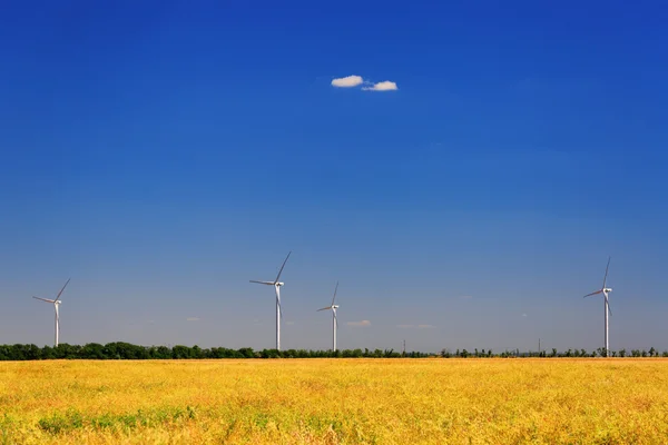 Wind turbine on a background of field and blue sky — Stock Photo, Image