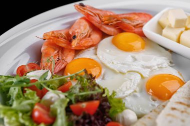 Kahvaltıda yumurta salatası kıtır ekmek tereyağlı karides ve beyaz tabak.