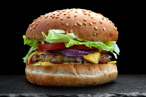 Burger, cheeseburger, hamburger with meat cutlet, cheese, lettuce and tomato, on a black background