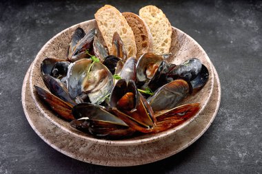 Krem peynir soslu midye yumuşakçaları, bir tabakta, fotokopi alanı olan koyu bir arka planda. Yatay