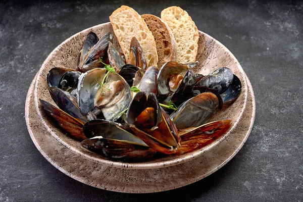 Krem peynir soslu midye yumuşakçaları, bir tabakta, fotokopi alanı olan koyu bir arka planda. Yatay