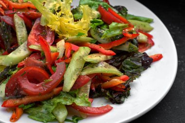 Koyu arkaplanda taze sebze salatası.