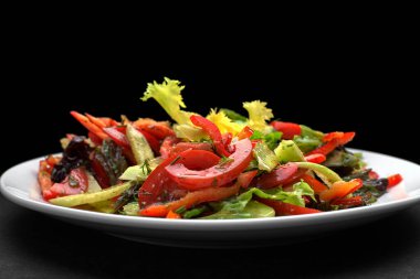 Koyu arkaplanda taze sebze salatası.