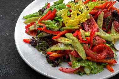 Koyu arkaplanda taze sebze salatası.