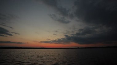 Gölde gün batımı, bulutlar ve yansımalarla dolu bir nehir.