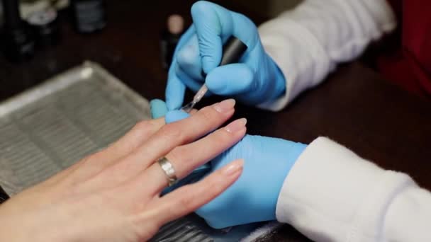 De manicure bedekt de nagels met de basis — Stockvideo