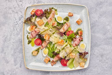 Sezar salatası, sebzeli tavuk pastırmalı pastırmalı yumurta ve domatesli, açık arkaplanlı.