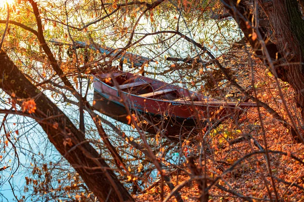 Tarde de otoño en una orilla del río desierta con un viejo puente de pesca y un barco pesquero. Nadie. Fotos de stock