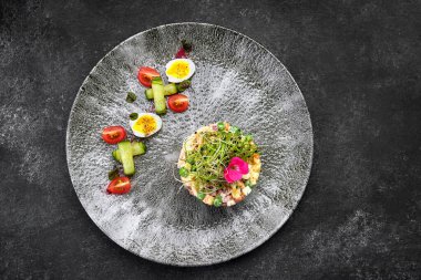 Olivier salatası gri güzel bir tabakta, koyu bir arka planda. Restoran servisi