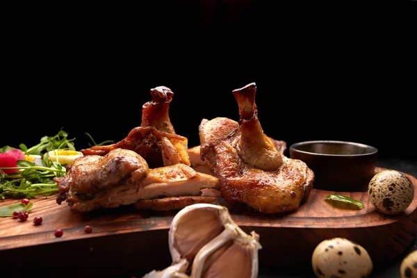 Grilled chick with herbs and sauce on a wooden board. on a black background — Stock Photo, Image
