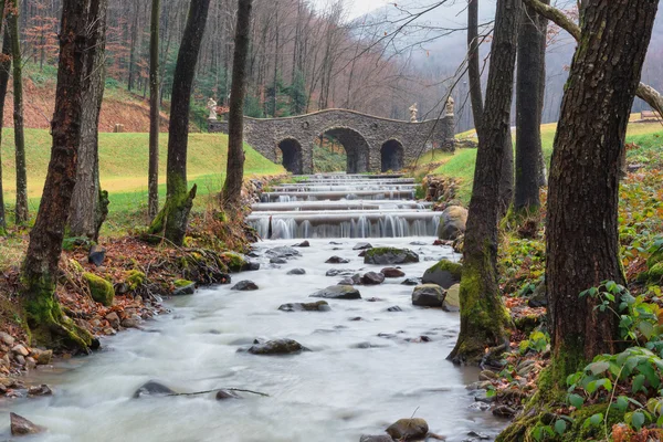 Parc d'automne avec un pont sur la rivière — Photo