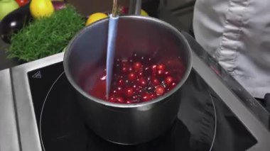 Şef mutfakta yaban mersini şurubu, tatlı tatlı malzemesi ve yemek pişirme süreci hazırlıyor..