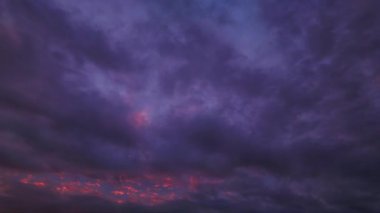 Parlayan gökyüzü ve renkli hareket eden bulutlarla, barışı ve doğal güzelliği simgeleyen çarpıcı bir gündoğumu videosu..