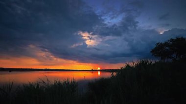 Sakin bir nehir üzerinde huzurlu altın gün batımı, yumuşak renkler ve sakin atmosfer, doğa, seyahat ve rahatlama temaları için ideal..