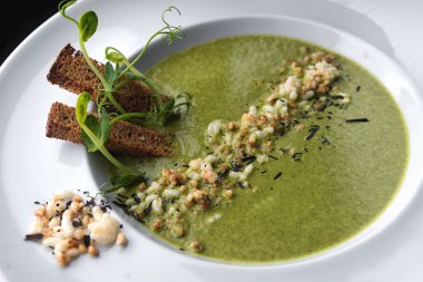 Beyaz kasede servis edilen sağlıklı kremalı ıspanak çorbası..