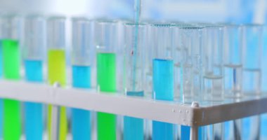 Laboratuvar biyokimyagerinin test tüpüne yağ damlatarak bitki ve organik kozmetoloji çalışması yapması..