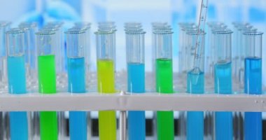 Pipetli bir bilim adamı laboratuardaki test tüplerindeki DNA ve molekülleri çıkarmak için sıvıyı analiz eder. Konsept: araştırma, biyokimya, ilaç