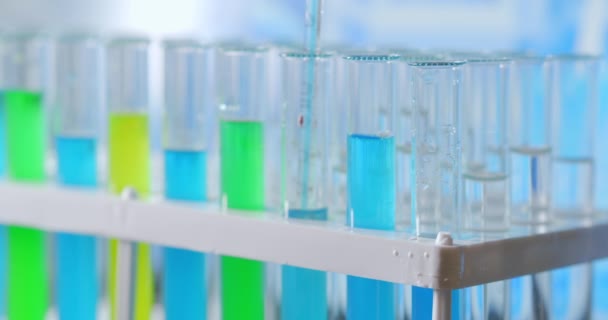 Biochimiste de laboratoire égouttant de l'huile dans une éprouvette avec une étude de cosmétologie végétale et organique. — Video
