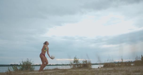 Allenamento della squadra di beach volley su campo di sabbia aperto, giocatore femminile sta servendo palla, squadra di sport femminile — Video Stock