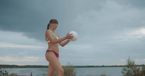 Sportowa kobieta serwuje piłkę podczas meczu siatkówki plażowej, treningów i przygotowań do zawodów, średni strzał — Wideo stockowe