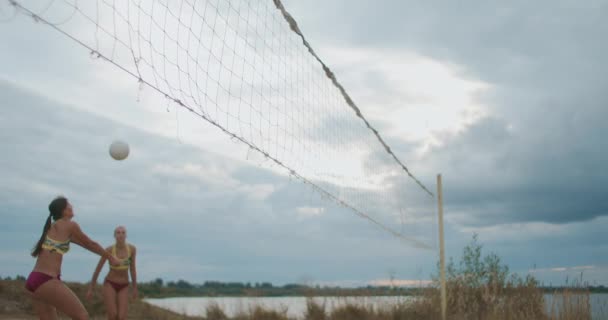 Zwei professionelle Volleyballspielerinnen attackieren andere Mannschaft auf offenem Beachcourt, Zeitlupe — Stockvideo