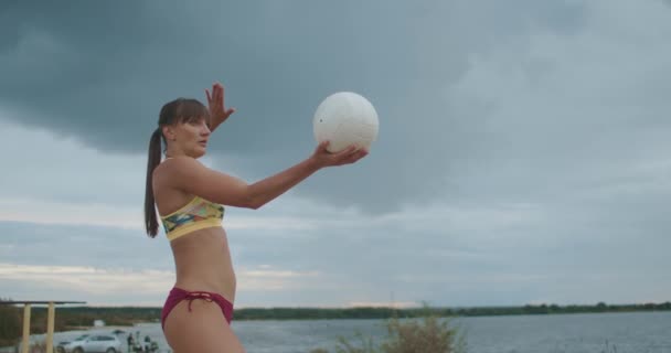 女性同士のビーチバレーの選手権、選手のポートレートショットがプレーにボールを提供し、スポーツ女性はスポーティーなビキニを着て — ストック動画