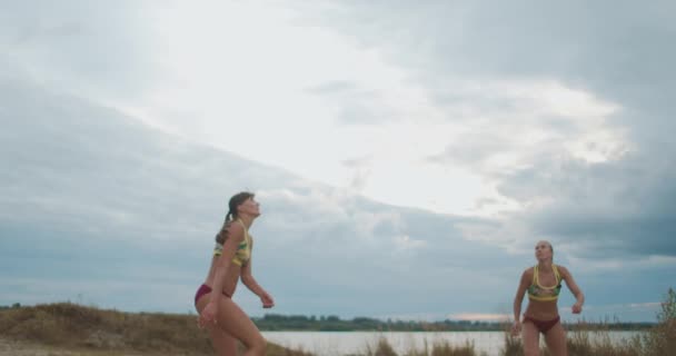 Two professional beach volleyball player women are attacking other team on open sand court, slow motion shot of movements — Stock Video