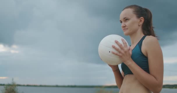 배구 공을 든 젊은 스포츠맨의 사진, 그녀는 야외 코트, 비치 배구 대회에서 봉사하고 있습니다. — 비디오