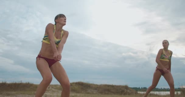 Match mellan två damer team av beachvolleyboll på sommaren dag, slow motion mot molnig himmel, kvinnor vilar på naturen — Stockvideo