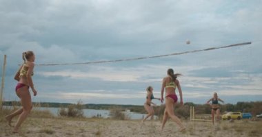 Kadınlar ve bayan oyuncular arasında gayri resmi plaj voleybolu müsabakası var.